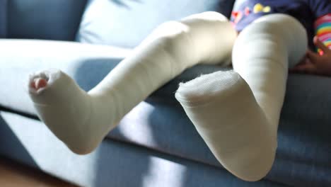 child with leg cast on couch