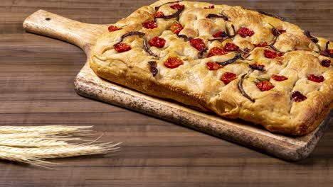 Traditional-Italian-Focaccia-with-pepperoni,-cherry-tomatoes,-black-olives,-rosemary-ando-onion---homemade-flat-bread-focaccia