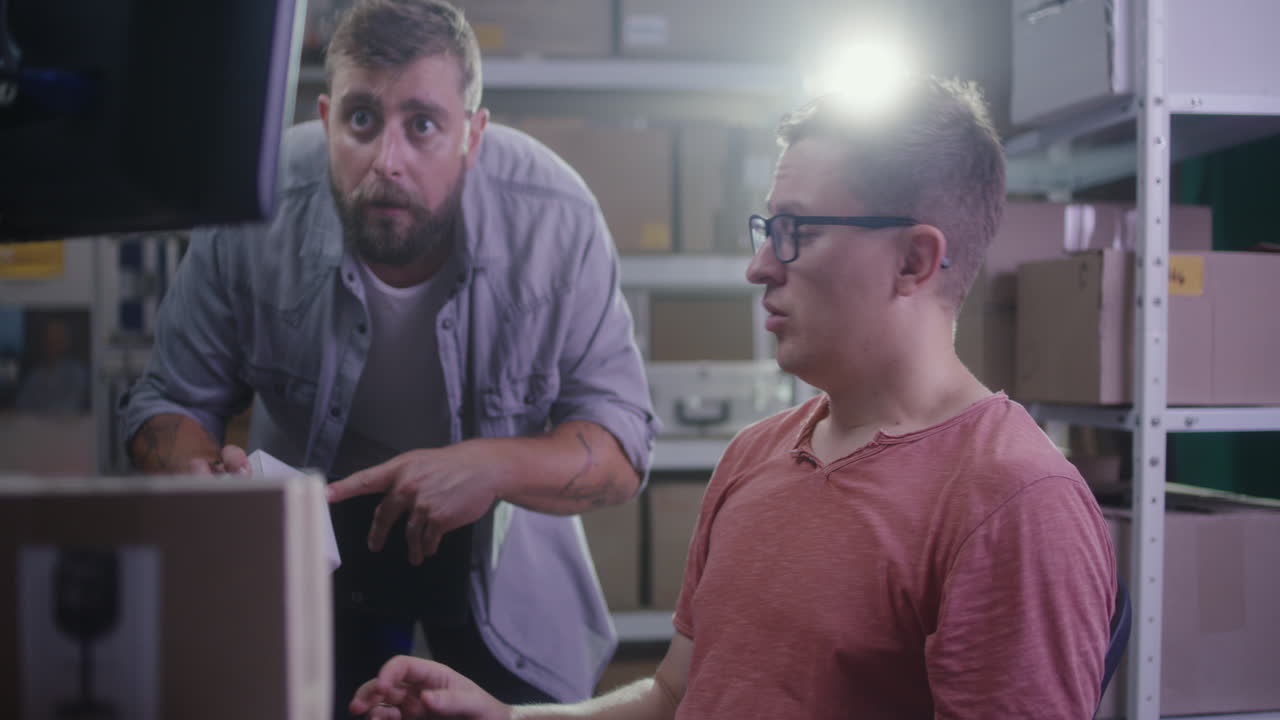 Two men working together in a warehouse office