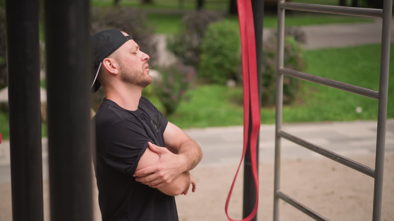 Fixing Outdoor Strap, Person Tightening And Adjusting Red Strap During Park Workout Session, Man Is Securing And Adjusting His Red Strap While Performing Outdoor Exercise Activities In Park