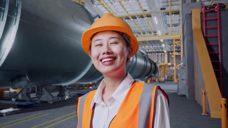 close up side view of asian female engineer with safety helmet looking around while standing in pipe manufacturing factory