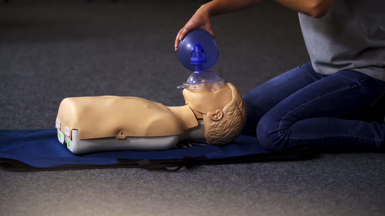 Medical doll lays on blue blanket ready for training. First medical help with oxigen masks video training.