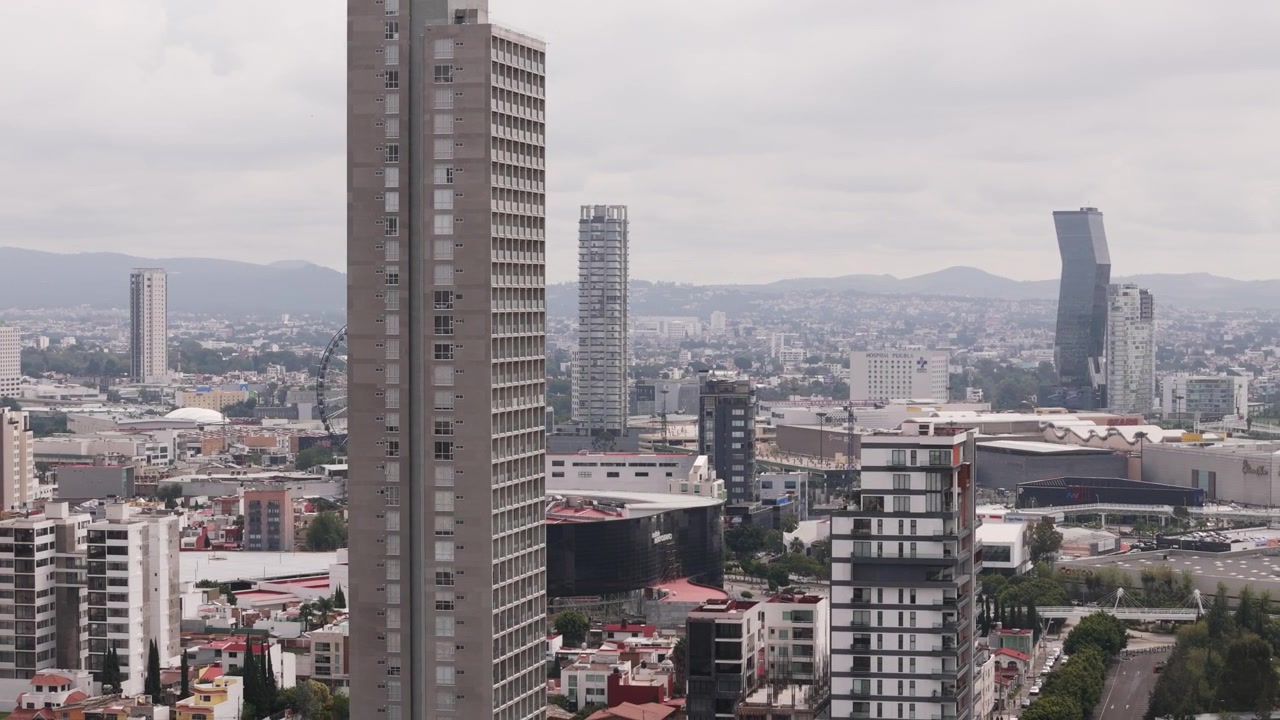 Vista aerea con drone dello skyline di Puebla, Messico, con una ruota panoramica gigante e montagne distanti