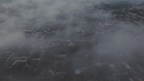 antigua guatemala with agua volcano in back during foggy sunrise, aerial