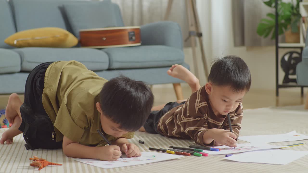 플라스틱 장난감 벽돌로 방 바닥에 누워있는 아시아 아이들의 클로즈업 집에서 함께 그림