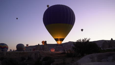 cámara lenta de una llama disparando a un globo aerostático ascendente al amanecer en capadocia, turquía