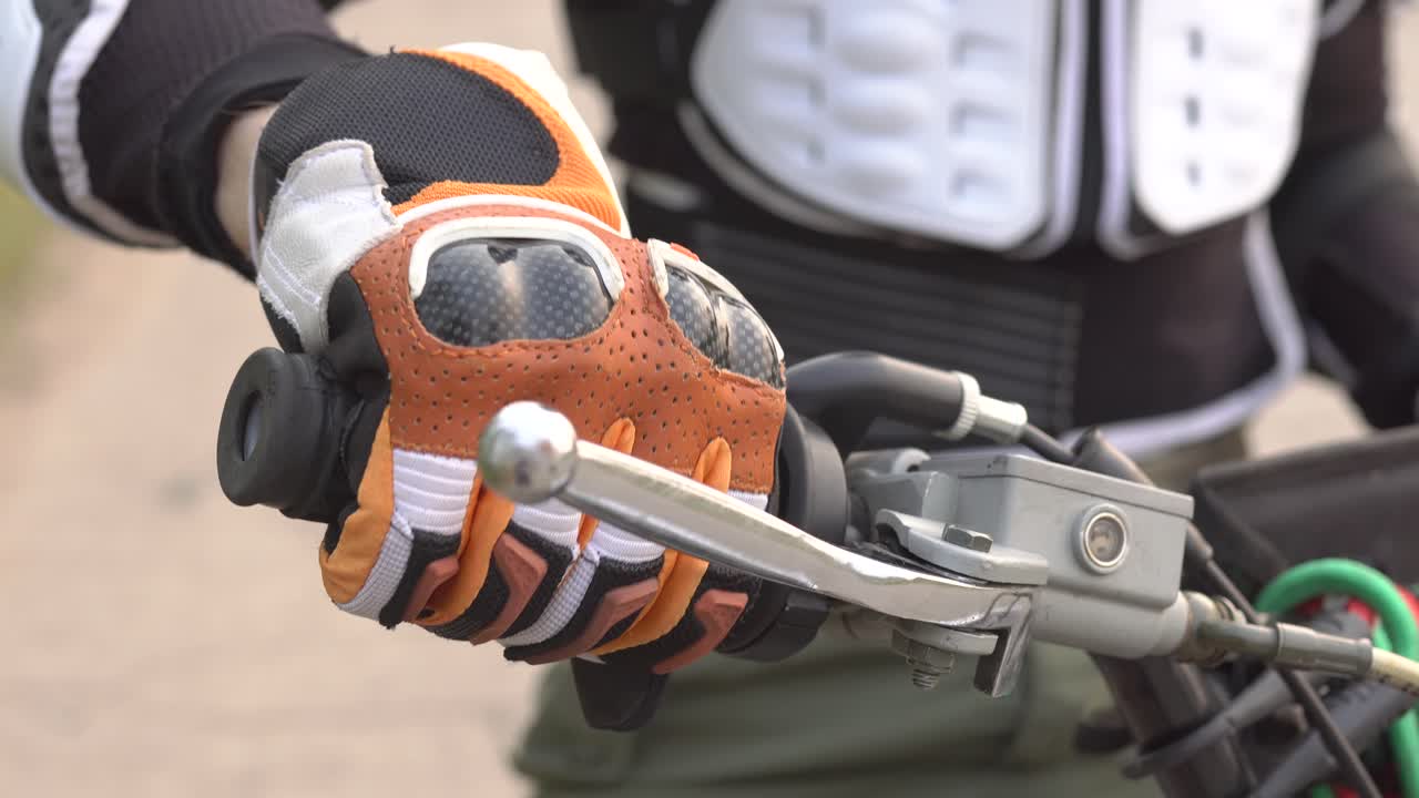 primer plano de las manos del motociclista en el manillar de la motocicleta