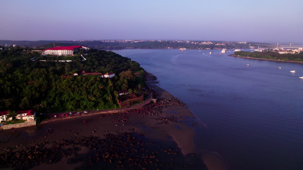 mandovi river with Reis Magos Fort, Naval War College and forest at Quegdevelim Beach, panaji, goa, india. day time, circle shot, drone shot, 4k