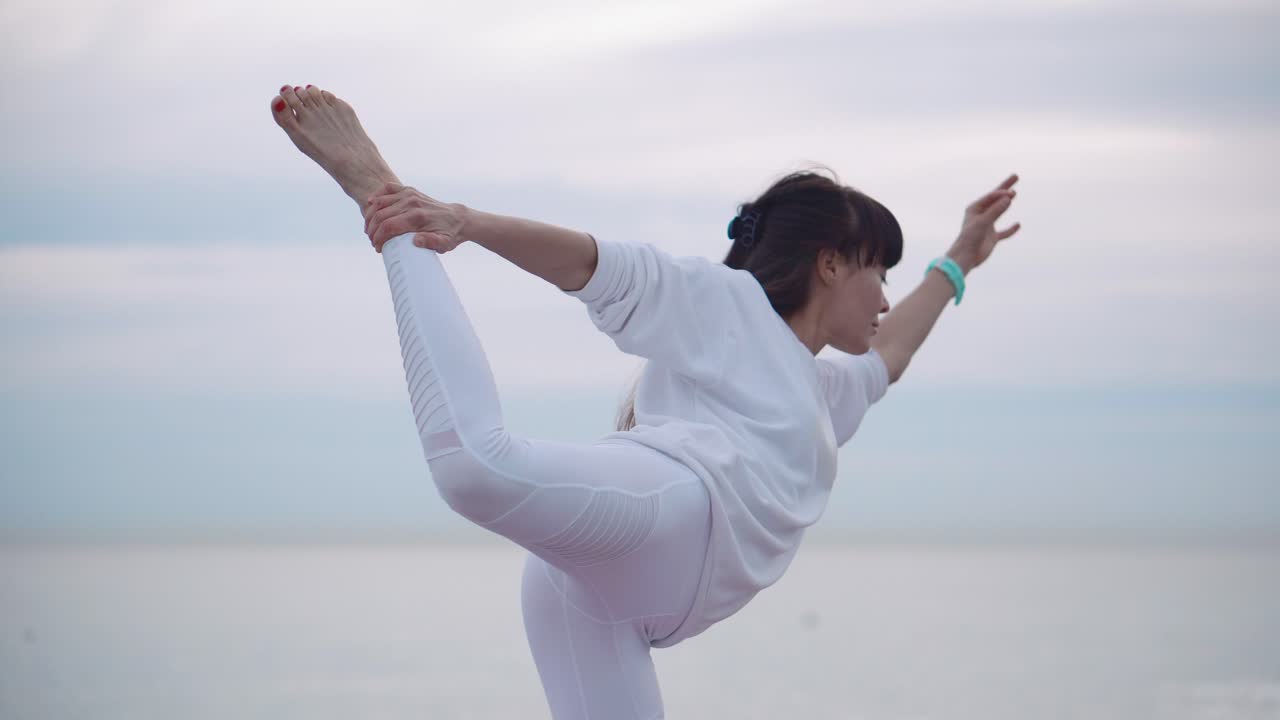 해변에서 요가를 연습하는 여자