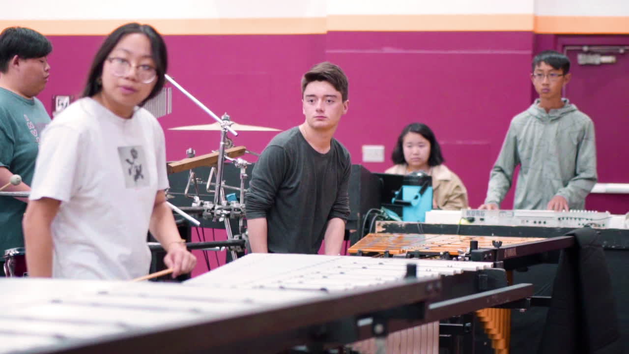 High school students rehearsing music and movement to the show they are to perform.
