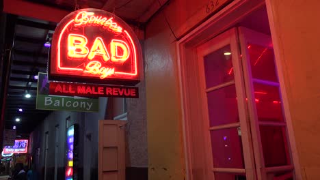 a neon sign advertises an all may revue bad boys on bourbon street in new orleans at night