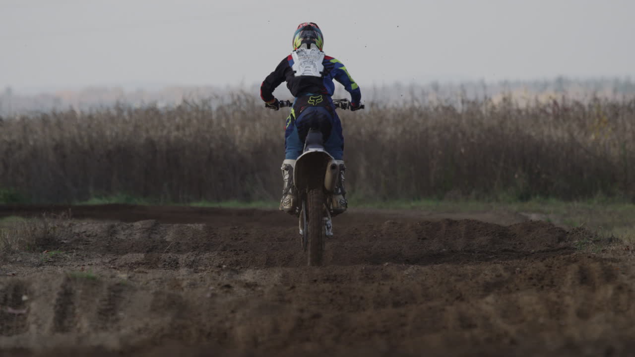 Motocross rider going through rhythm section from behind
