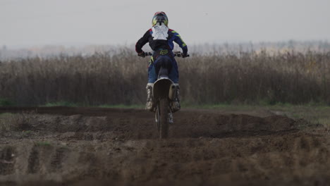 motocross rider going through rhythm section from behind