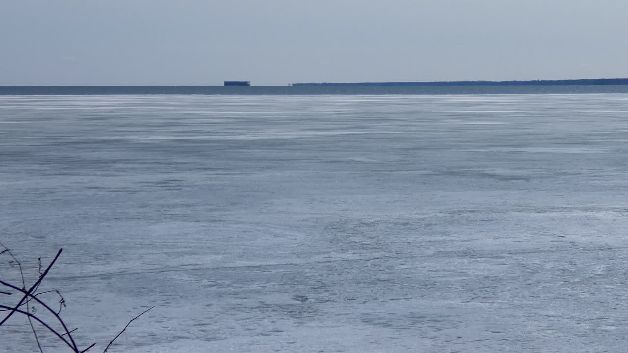 Ice retreats on a frozen bay in early spring.