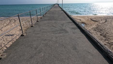 walking along a pier towards the sea