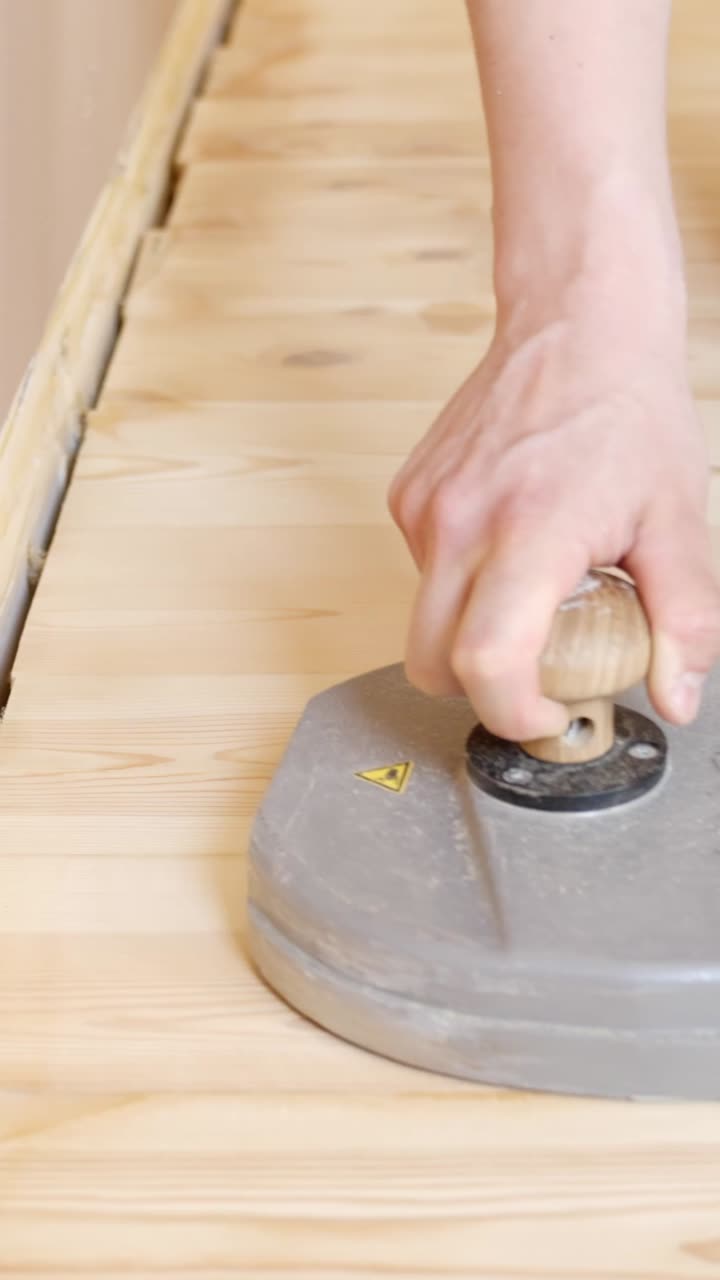 Wooden floor sanding process at edge with equipment in interior space