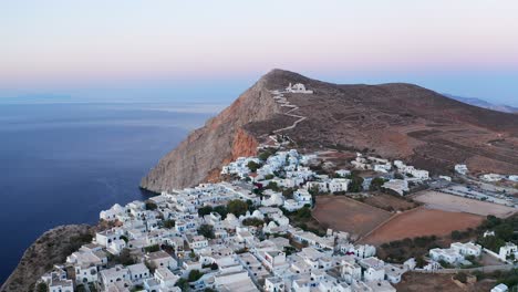 Vista-Panorámica-Aérea-Hermosas-Casas-Blancas-Típicas-Paisaje-De-La-Ciudad-Al-Atardecer,-Grecia