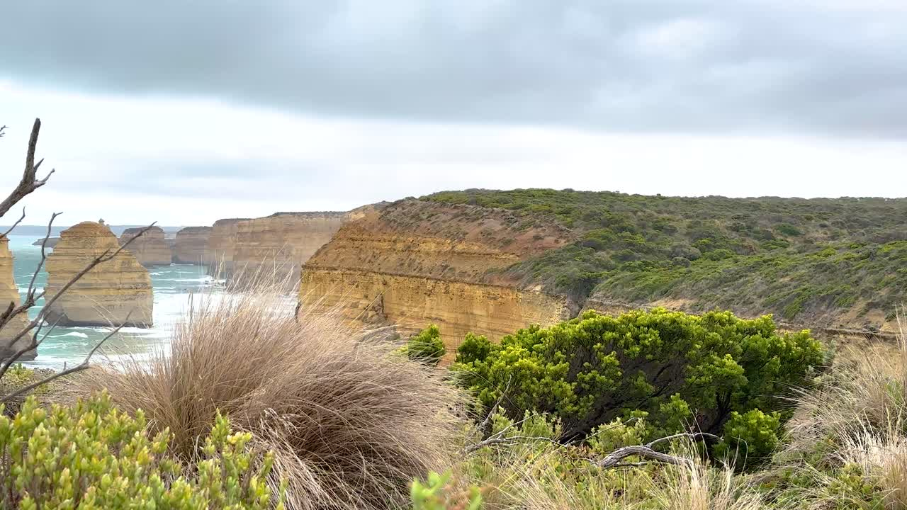 A serene coastal landscape featuring the iconic Twelve Apostles rock formations under overcast skies at Port Campbell, Australia