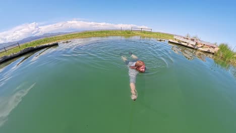 hot spring in utah with a red haired male jumping in and swimming