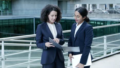 smiling businesswomen discussing papers