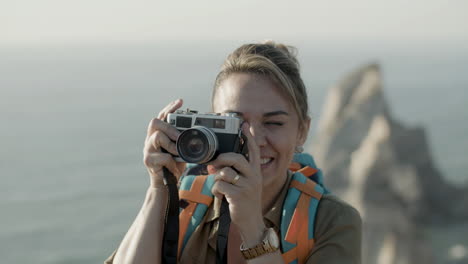 primer plano de una mujer rubia tomando fotos en las montañas durante la aventura de senderismo