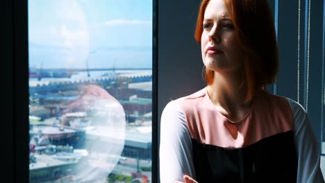 Female-executive-with-arms-crossed-in-office