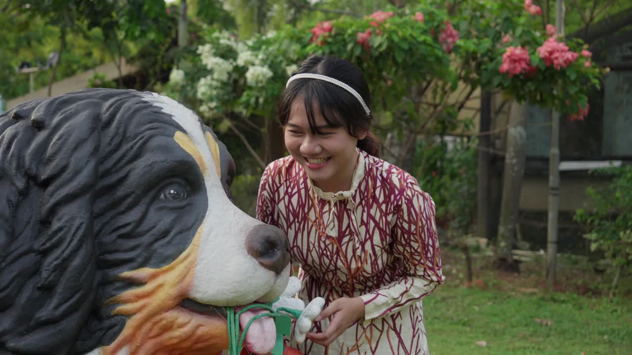 Happy girl in the garden found, a large statue dog close to the ground