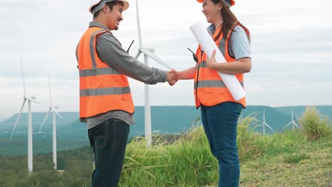 concepto progresivo de los ingenieros que trabajan en el parque eólico en la cima de la montaña.