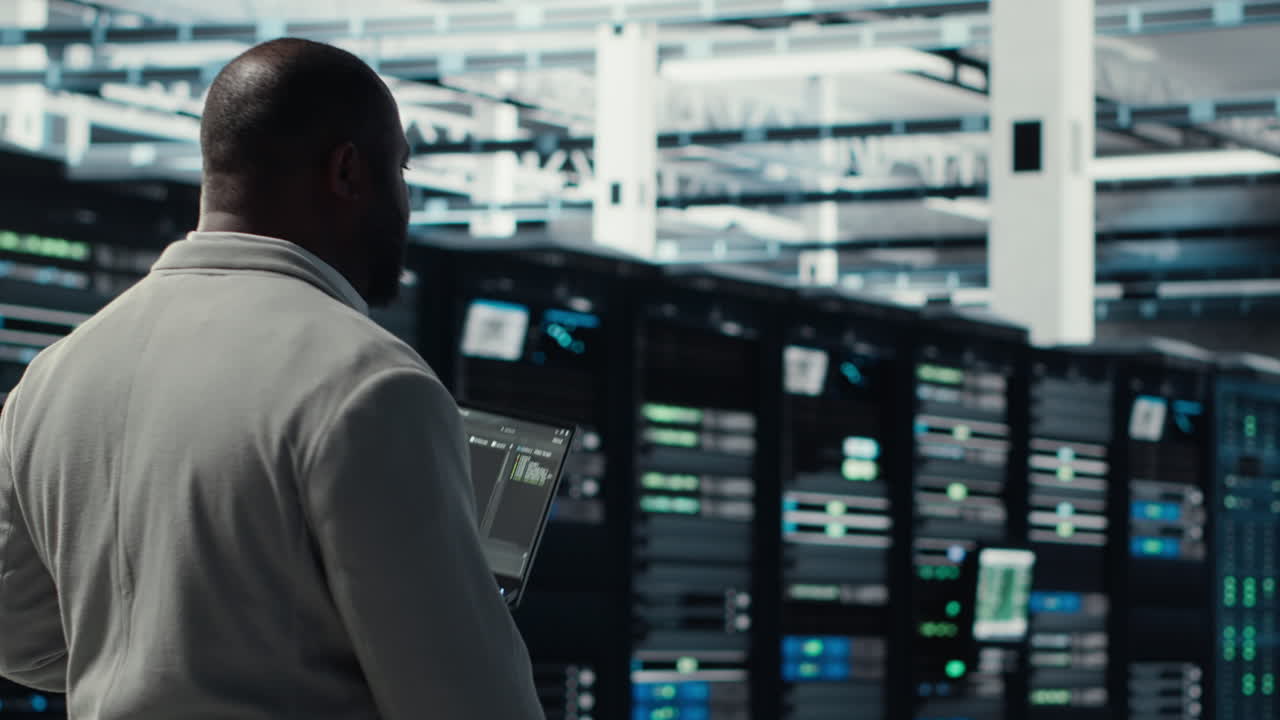 Vertical video Engineer walking in server farm, automating system diagnostics