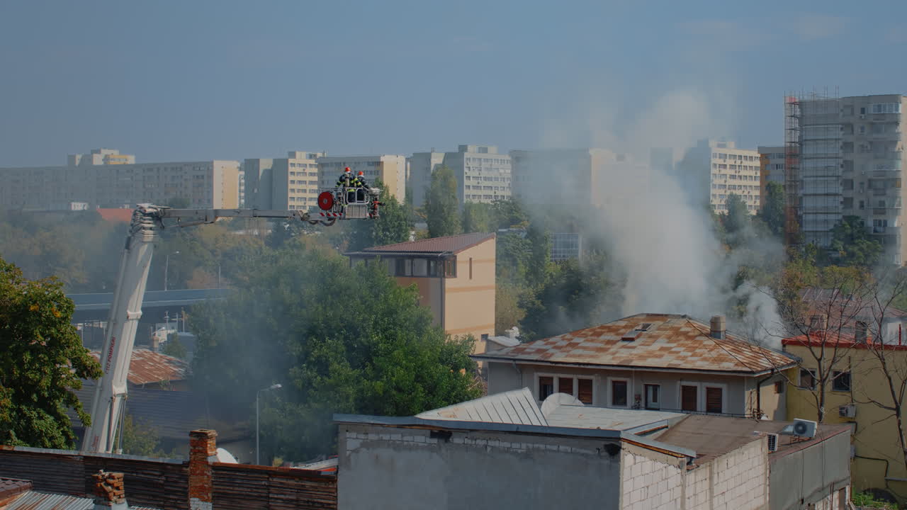 Firefighters using platform truck to help with house on fire