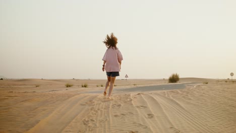 chica corriendo en el desierto al atardecer