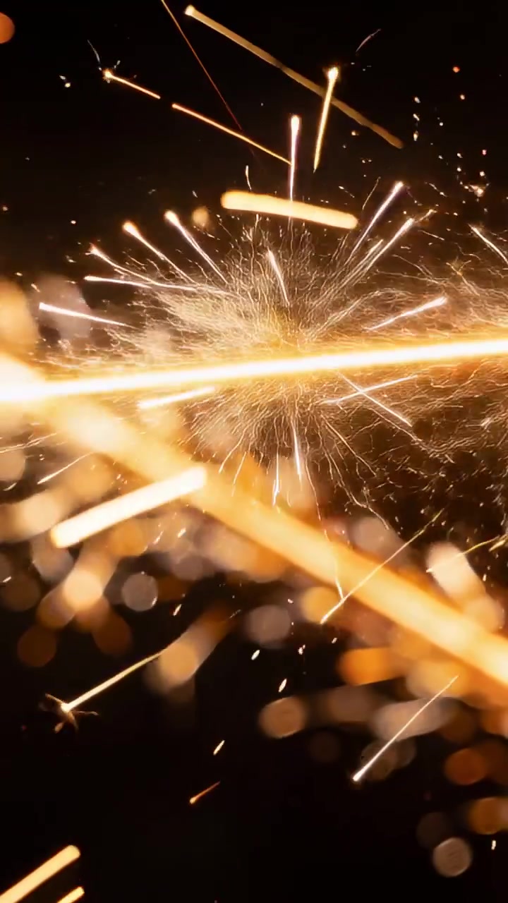 Video verticale: Accensione di una striscia centrale che invia scintille dorate attraverso lo studio, con particelle bokeh.