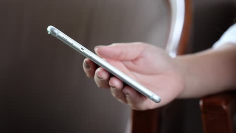 a woman's hand using and sliding touch screen smart phone in modern cafe