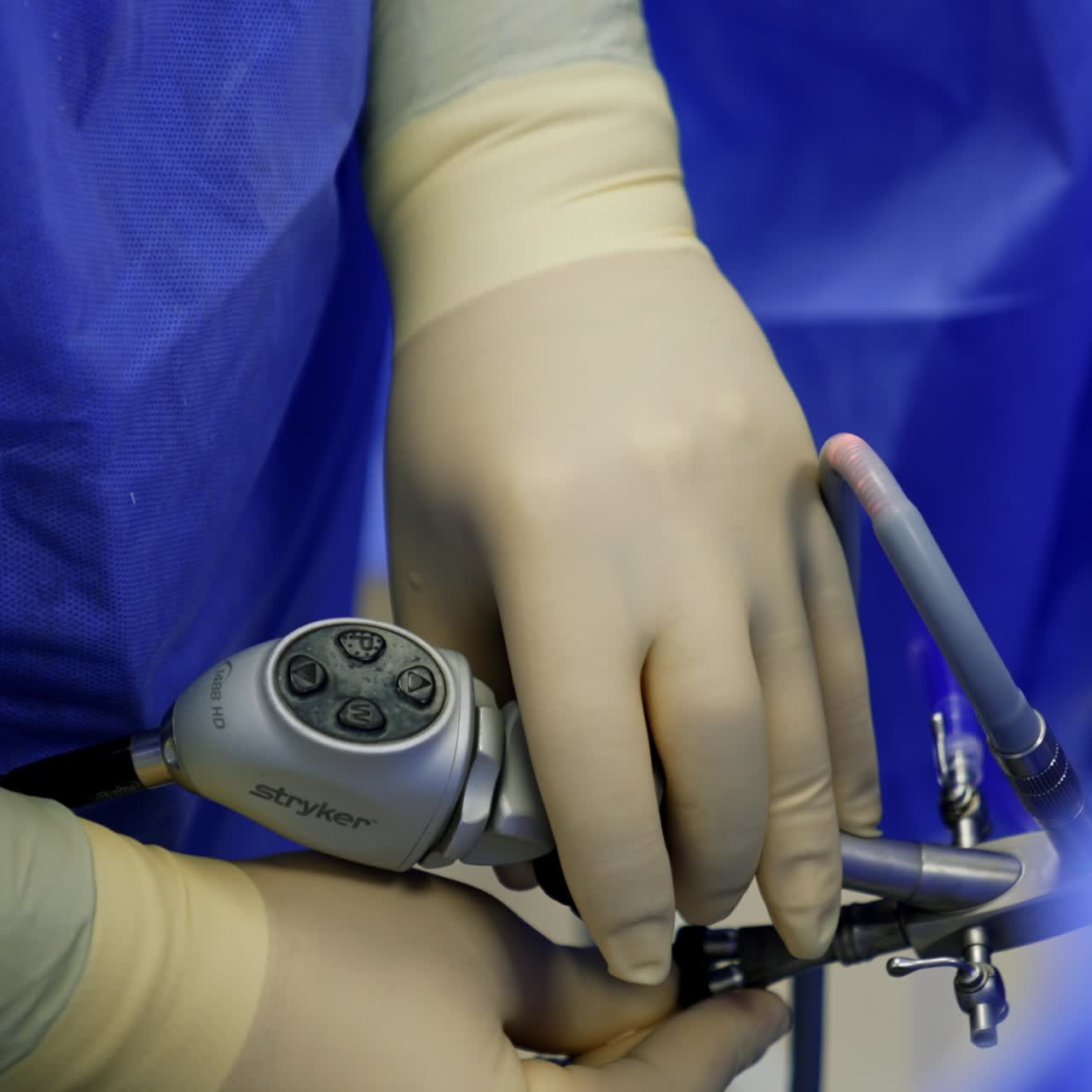 Medic in latex gloves applying the modern tool. Medical device is used in laparoscopic surgery. Close up