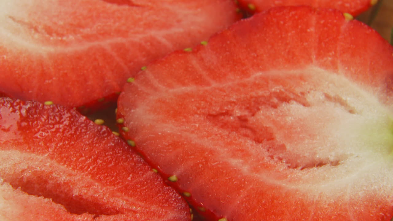 vista de inclinación macro 4k de fresas en rodajas, rodajas de fresa de cerca