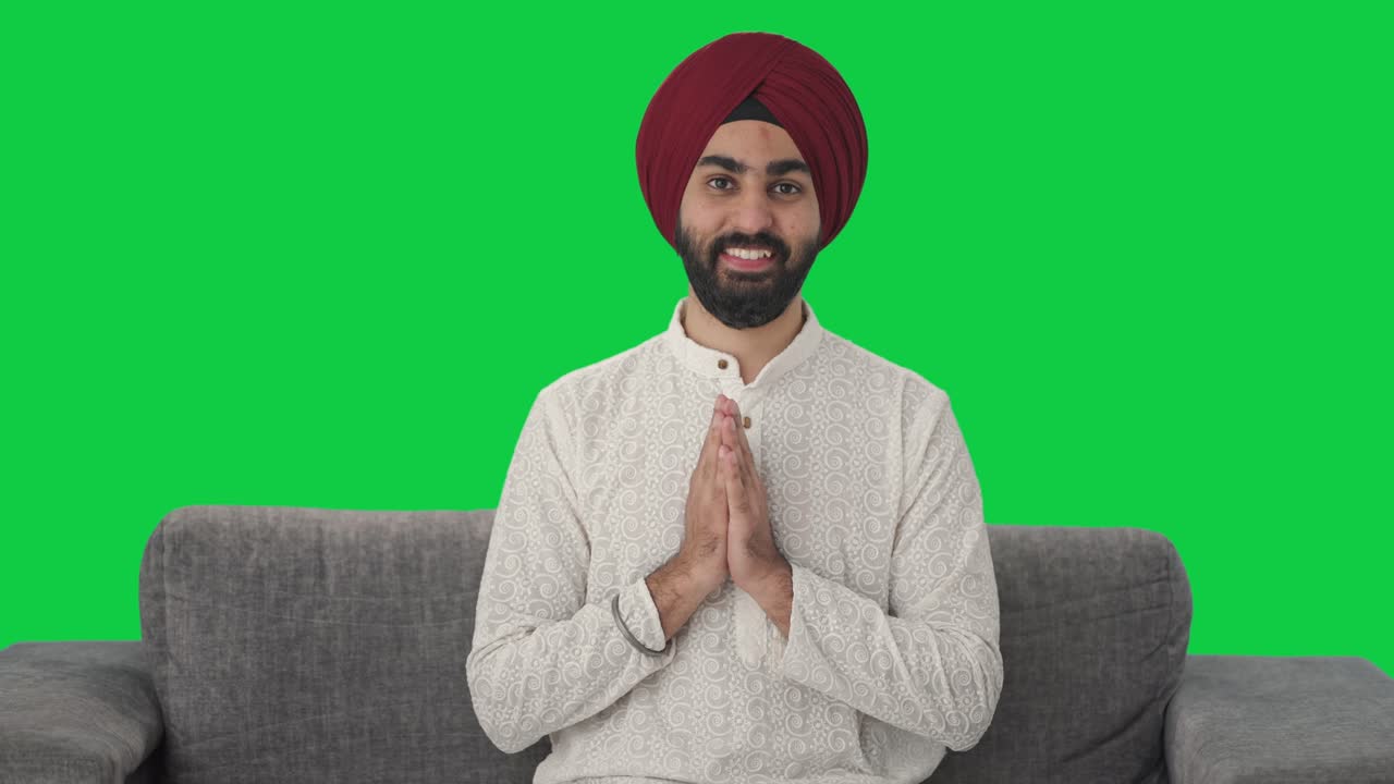 Happy Sikh Indian man doing Namaste Green screen