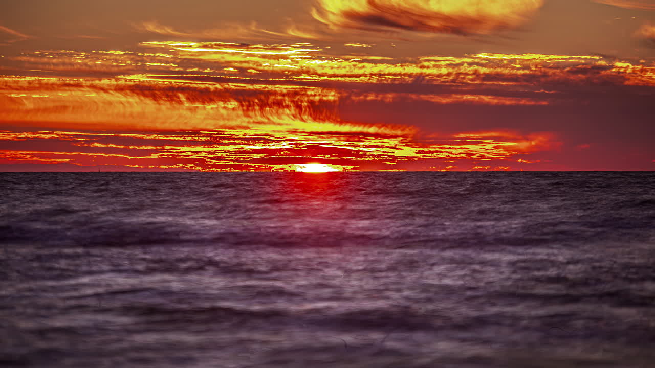 바다의 배경에 수평선 위로 timelaps에서 일몰의 보기