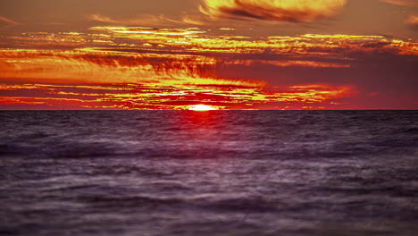 View-of-the-sunset-in-timelaps-over-the-horizon-on-the-background-of-the-ocean