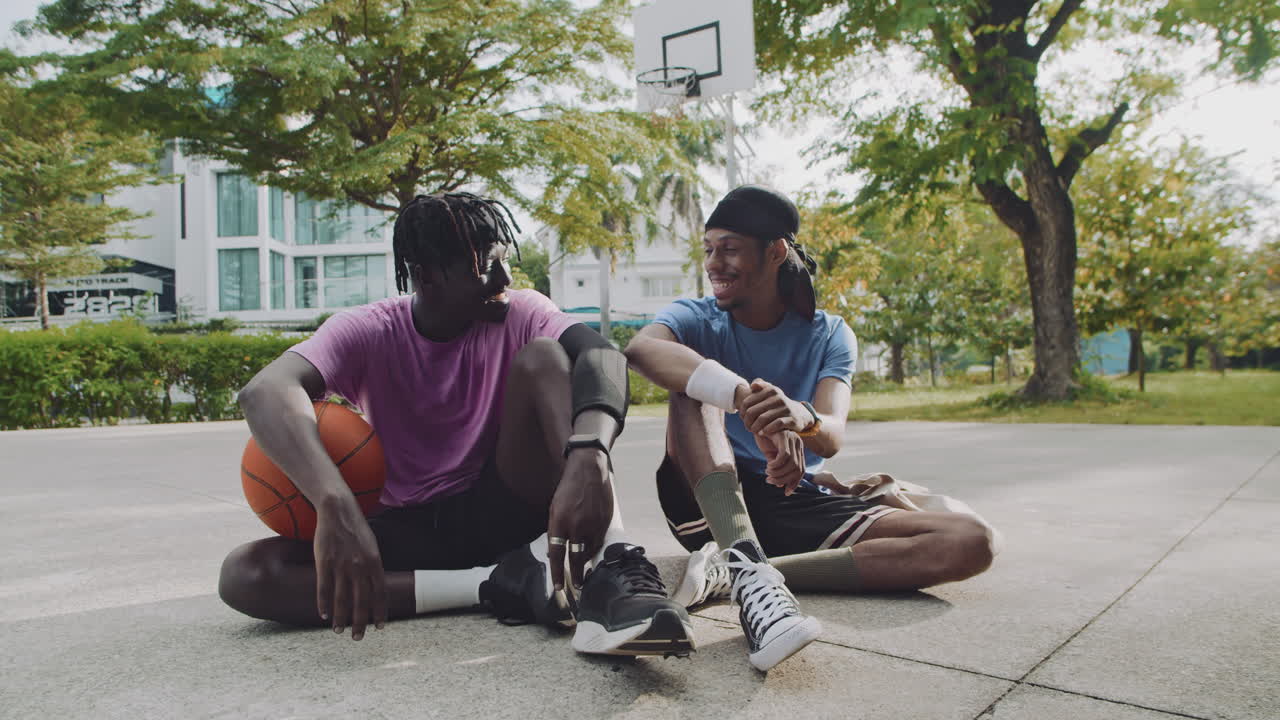 Portrait of Basketball Players Sitting on City Court Outdoors