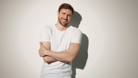 hombre sonriente con camiseta blanca y vaqueros