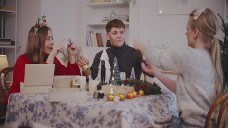 friends with decoration sitting at table in living room