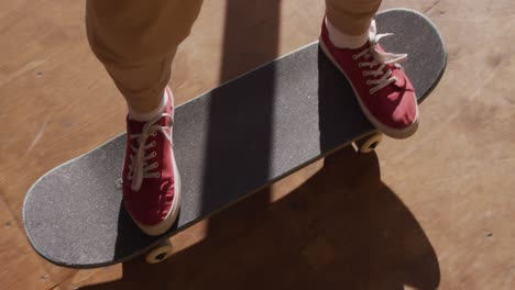 video of legs of caucasian female skateboarder training in skate park