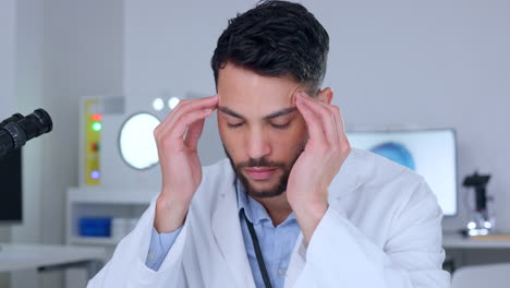 científico estresado con dolor de cabeza trabajando