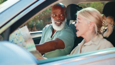 senior couple in car with map arguing about directions on day trip out