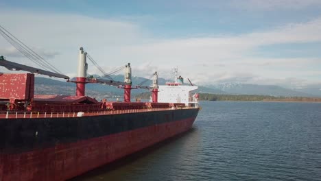 flying along the side of a bulk carrier ship anchored in burrard inlet near vancouver, bc, canada