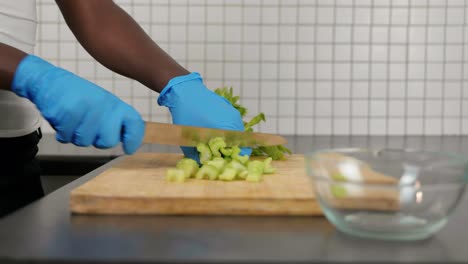 african lady cutting salary with gloves - food prep during covid