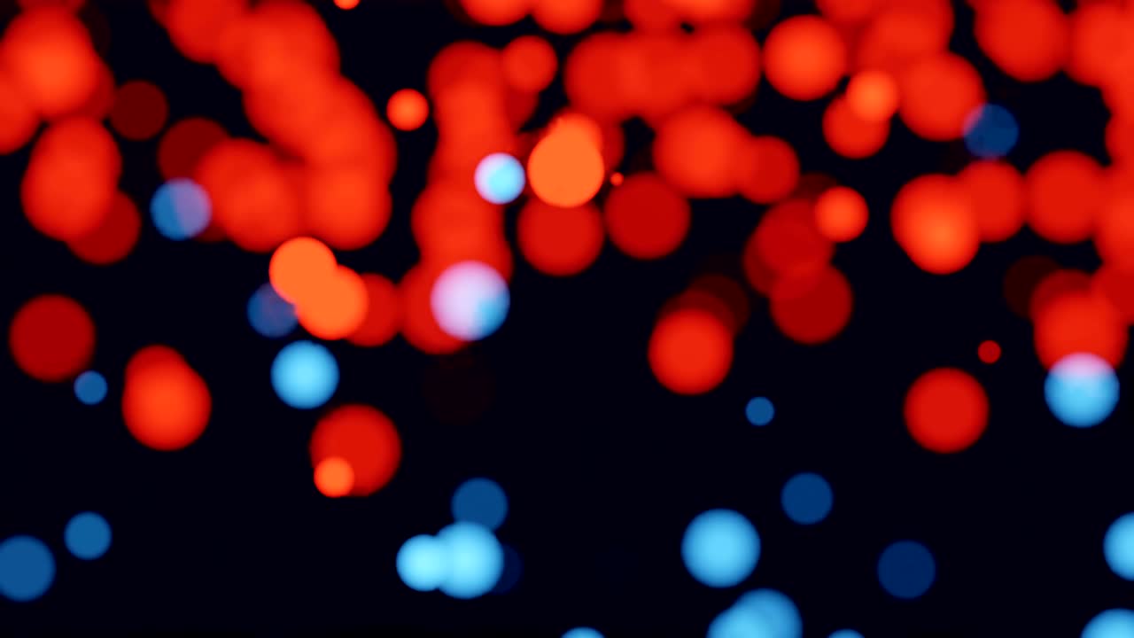 Movement of colorful bokeh or shiny particles on dark background