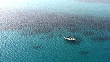 Velero-Blanco-Anclado-En-El-Agua-Azul-Clara-Del-Océano-Cerca-De-Las-Bahamas-En-Verano