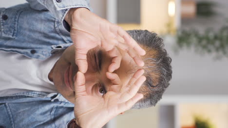 vertical video of man making heart sign at camera.