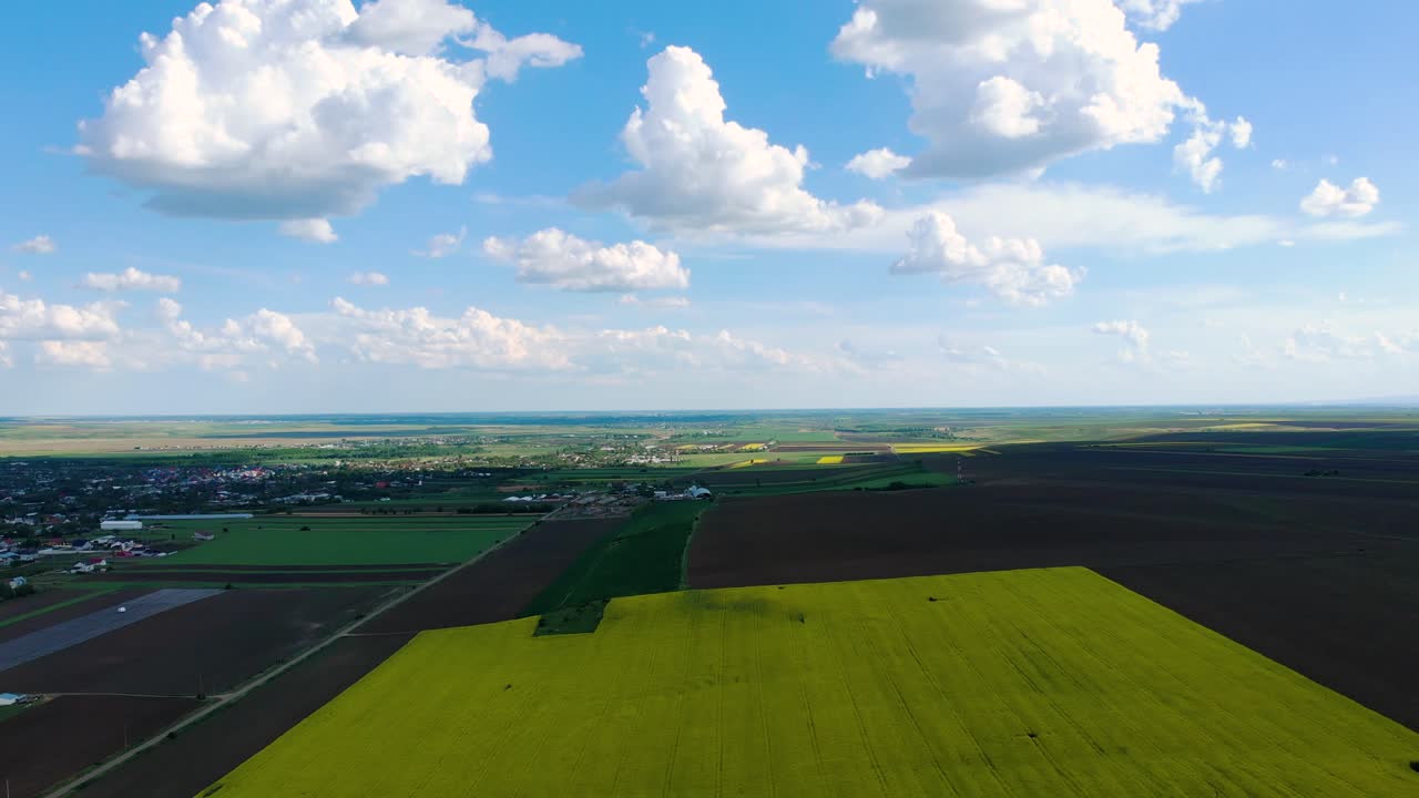 봄철 시골 근처의 유채밭 위에 클라우드스케이프가 있는 푸른 하늘
